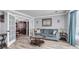 Cozy living room with hardwood floors, blue sofa, glass coffee table, and view to dining area at 100 Conset Bay Ct, Goose Creek, SC 29445