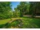 Scenic backyard displaying a small, tranquil pond surrounded by a lush lawn and various plantings at 100 S Gum St, Summerville, SC 29483