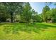 Backyard featuring a grassy lawn, mature trees, and a stone picnic table at 100 S Gum St, Summerville, SC 29483