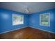 A blue bedroom features hardwood floors, two windows, and a ceiling fan with a light fixture at 100 S Gum St, Summerville, SC 29483