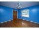 A blue bedroom features hardwood floors, one window, a closet, and a ceiling fan with a light fixture at 100 S Gum St, Summerville, SC 29483