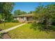 Charming brick home featuring a well-manicured lawn and mature trees on a sunny day at 100 S Gum St, Summerville, SC 29483