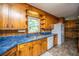 Kitchen with wood cabinets, blue countertops, and a window providing natural light at 100 S Gum St, Summerville, SC 29483