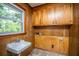 Functional laundry area with built-in wood cabinets, utility sink, and a window for natural light at 100 S Gum St, Summerville, SC 29483