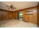 Spacious living room featuring wood paneling, a ceiling fan, and a sliding glass door at 100 S Gum St, Summerville, SC 29483