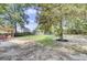 Expansive backyard with a pergola, lush lawn, and mature trees offering shade at 103 Trimley Ct, Goose Creek, SC 29445