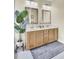 Bathroom featuring a double sink vanity with ample cabinet space, neutral colored tile, and a gray rug at 103 Trimley Ct, Goose Creek, SC 29445