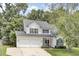Charming two-story home with a two-car garage, a well-manicured lawn, and beautiful trees providing shade at 103 Trimley Ct, Goose Creek, SC 29445
