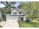 Charming two-story home with a two-car garage, a well-manicured lawn, and beautiful trees providing shade at 103 Trimley Ct, Goose Creek, SC 29445