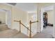 Upstairs hallway featuring wood railing, neutral carpet, modern light fixture and open doorways at 103 Trimley Ct, Goose Creek, SC 29445