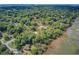 Aerial view of a wooded neighborhood with waterfront access, showing homes nestled among mature trees and marshland at 1102 N Shadow Dr, Mount Pleasant, SC 29464