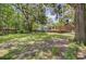 Large backyard with mature trees, a well-maintained lawn, and a view of the house including its sunroom at 1102 N Shadow Dr, Mount Pleasant, SC 29464