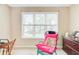 Bright bedroom featuring large windows, a chair with a pink cushion, and a wooden desk at 1102 N Shadow Dr, Mount Pleasant, SC 29464