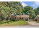Inviting single story brick home featuring a cozy porch, attached garage, and mature landscaping at 1102 N Shadow Dr, Mount Pleasant, SC 29464