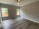 Bright bedroom with hardwood floors and two windows offering natural light and green views at 110A Dukes St, Saint George, SC 29477