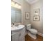 Elegant half bathroom features decorative wallpaper and hardwood floors at 1116 Sea Island Crossing Ln, Mount Pleasant, SC 29464