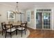 Dining area with elegant chandelier and natural light, adjacent to outdoor patio, and a view to kitchen at 1116 Sea Island Crossing Ln, Mount Pleasant, SC 29464