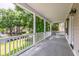 Comfortable porch overlooks expansive lawn, framed by mature trees and tidy landscaping at 1116 Sea Island Crossing Ln, Mount Pleasant, SC 29464