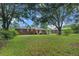 Wide shot of the backyard featuring mature trees and lush lawn at 116 Lyle Rd, Goose Creek, SC 29445