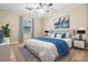 Cozy bedroom featuring a plush bed with a blue blanket, soft lighting, and natural light from a large window at 116 Lyle Rd, Goose Creek, SC 29445