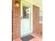 Close-up of the front door with decorative wreath, set in a classic brick facade at 116 Lyle Rd, Goose Creek, SC 29445