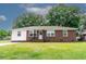 Charming brick and vinyl ranch-style home with a well-manicured lawn and mature trees creating a serene atmosphere at 116 Lyle Rd, Goose Creek, SC 29445