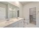 Bathroom with a double sink vanity, white marble shower, and access to the walk-in closet at 117 Oyster Tide Ave, Summerville, SC 29485