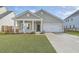 Charming single-Gathering home with a well-manicured lawn, attached garage, and inviting front porch with white pillars at 117 Oyster Tide Ave, Summerville, SC 29485