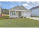 Charming single-Gathering home with a well-manicured lawn, attached garage, and inviting front porch with white pillars at 117 Oyster Tide Ave, Summerville, SC 29485