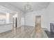 Open-concept living room with fireplace, hardwood floors, and seamless flow to the modern kitchen at 117 Oyster Tide Ave, Summerville, SC 29485