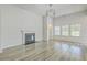 Open-concept living room with hardwood floors, fireplace, modern lighting, and abundant natural light at 117 Oyster Tide Ave, Summerville, SC 29485