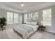 Bright bedroom features large windows, ceiling fan, stylish decor, and a comfortable bed with plush pillows at 119 Crosscut Ln, Summerville, SC 29486