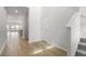 Bright hallway with hardwood floors, white walls, staircase and doorway leading to an open-concept living space at 119 Lefton Lndg, Summerville, SC 29485