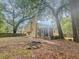 Spacious backyard featuring a fire pit, mature trees, and a wooden fence for privacy at 119 Scottswood Dr, North Charleston, SC 29418