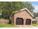 Spacious two-car garage with brick facade and black doors, surrounded by a lush green lawn at 119 Scottswood Dr, North Charleston, SC 29418
