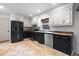 Modern kitchen with black stainless steel appliances, hardwood floors, and white and black cabinets at 119 Scottswood Dr, North Charleston, SC 29418
