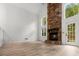 Bright, modern living room featuring a soaring stone fireplace, ample light and wood-look floors at 119 Scottswood Dr, North Charleston, SC 29418