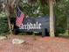 Community sign with the name 'Archdale' and a US Flag in a neighborhood with lush trees at 119 Scottswood Dr, North Charleston, SC 29418
