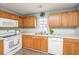 Functional kitchen featuring light wood cabinets, white appliances, and a stainless steel sink at 129 Dovetail Cir, Summerville, SC 29483
