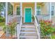 Charming home entrance featuring a bright teal door with a wreath and beautiful flower bushes at 1338 Addykay Pl, North Charleston, SC 29406
