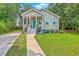 Inviting home showcasing a well-manicured lawn, charming porch, and a vibrant teal front door at 1338 Addykay Pl, North Charleston, SC 29406