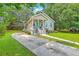 Quaint home with a long driveway and lush green lawn, framed by mature trees, exuding curb appeal at 1338 Addykay Pl, North Charleston, SC 29406