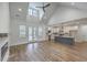 Open-concept living room features wood floors, vaulted ceilings, modern fireplace, and kitchen access at 136 Mitch Ln, Holly Hill, SC 29059