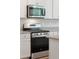 Stainless steel gas range and microwave complement the white cabinetry and granite countertops at 139 Sunray Ln, Summerville, SC 29486