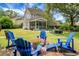 Beautiful backyard with a patio, blue Adirondack chairs, and a screened-in porch at 1422 Iroquois St, North Charleston, SC 29405