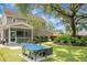 Expansive backyard featuring a ping pong table, lush landscaping, and outdoor seating at 1422 Iroquois St, North Charleston, SC 29405