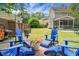Outdoor patio with blue Adirondack chairs, lush lawn, and charming backyard views at 1422 Iroquois St, North Charleston, SC 29405