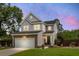 Exterior home view with a two-car garage, nice front yard, and welcoming porch at twilight at 1422 Iroquois St, North Charleston, SC 29405