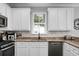 Kitchen with granite countertops, stainless steel appliances, white cabinetry, and natural light at 1422 Iroquois St, North Charleston, SC 29405