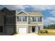 Exterior of a tan townhome features black shutters and a single-car garage, under a partly cloudy blue sky at 144 Haventree Ct, Summerville, SC 29486